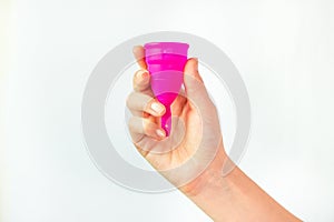 Young woman hand holding a pink menstrual cup