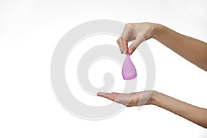 Young woman hand holding a pink menstrual cup - white background. Gynecology concept