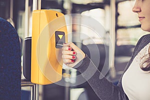 Young woman hand inserts the bus ticket into the validator, validating and ticking, public transportation concept