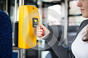 Young woman hand inserts the bus ticket into the validator, validating and ticking, public transportation concept