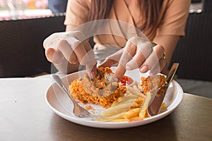 in young woman hand select focus, Hand with fried chicken blur background, Close-up Fried chicken