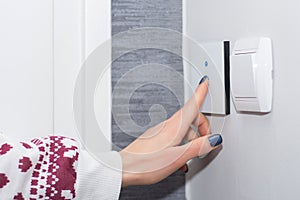 Smart Home Convenience: Young Woman Controlling Light with Touch Switch