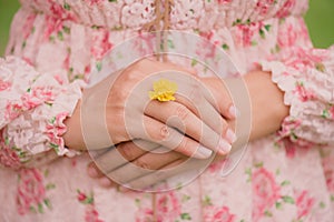 Young woman hand wearing Yellow flower represent of wedding ring