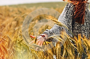 Young woman hand in a wheat field as harvest concept