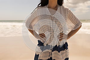 Young woman with hands on hip standing on beach