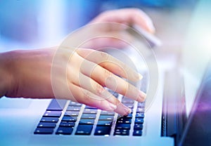 Young woman hands holding credit card and using laptop computer