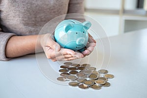 Young woman hands protection piggy bank and planning growing saving to strategy with pile coins for future plan fund of travel,