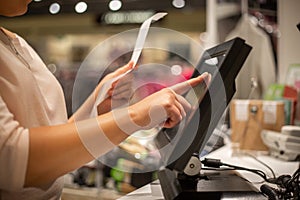 Young woman hands scaning, entering discount, sale on a receipt, touchscreen cash register