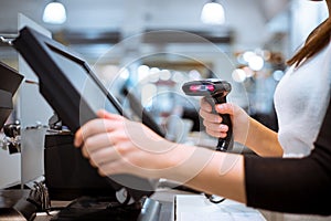 Young woman hands scaning, entering discount, sale on a receipt, touchscreen cash register, POS, finance concept