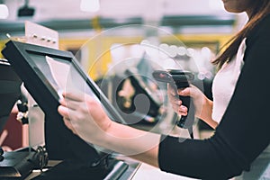 Young woman hands scaning, entering discount, sale on a receipt, touchscreen cash register, POS, finance concept