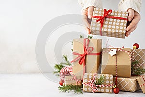 Young woman hands taking a gift box from a big stack of gifts