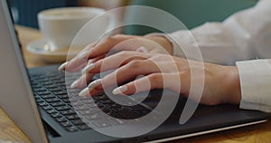 Young woman hands using laptop computer studying in cafe student drinking coffee typing email messages browsing online