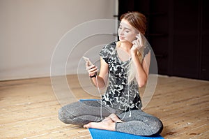 Young woman happy singing her favorite song while listening music sitting on the floor.