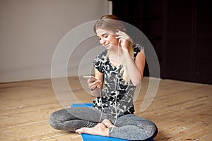 Young woman happy singing her favorite song while listening music sitting on the floor.