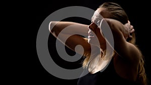 Young woman hardly breathing and screaming against dark background, problems