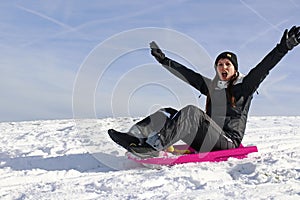 A young woman has fun sledging in winter