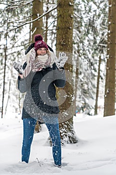 A young woman has fun in a winterly forest photo