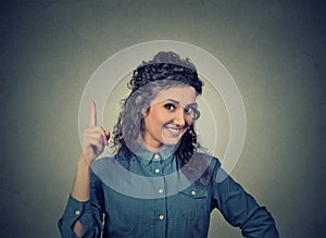 Young woman has idea, pointing with finger up