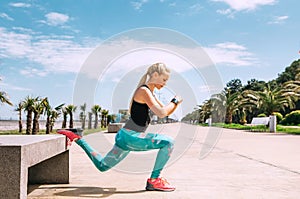 Young woman has an outdoor workout on the sea embankment