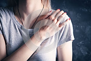 A young woman has a shoulder pain