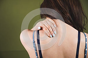 a young woman has a shoulder pain