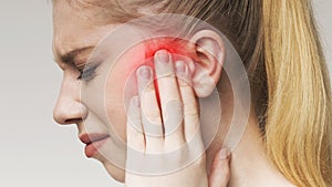 Young woman has sore ear, suffering from otitis photo