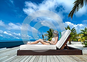 Young woman in hat with laptop at the beach