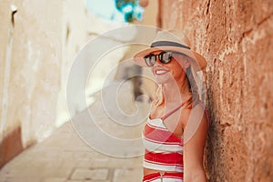 Young woman in hat on Mediterranean street toothy smile