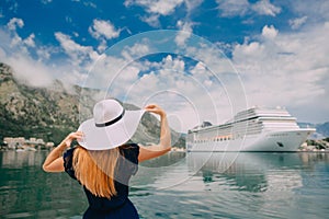 Woman in hat stands on cruise liner background, rear view