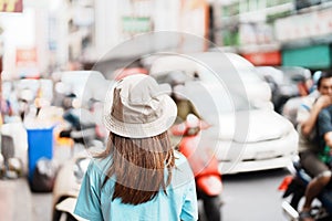 Young Woman with hat traveling in Bangkok, Asian traveler visiting at Yaowarat road or Chinatown of Bangkok, landmark and popular