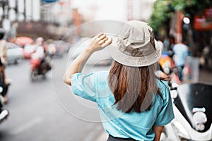 Young Woman with hat traveling in Bangkok, Asian traveler visiting at Yaowarat road or Chinatown of Bangkok, landmark and popular