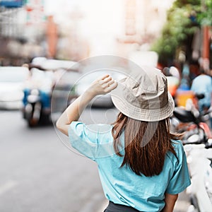 Young Woman with hat traveling in Bangkok, Asian traveler visiting at Yaowarat road or Chinatown of Bangkok, landmark and popular