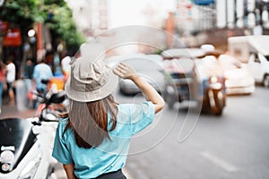 Young Woman with hat traveling in Bangkok, Asian traveler visiting at Yaowarat road or Chinatown of Bangkok, landmark and popular