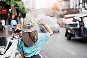 Young Woman with hat traveling in Bangkok, Asian traveler visiting at Yaowarat road or Chinatown of Bangkok, landmark and popular