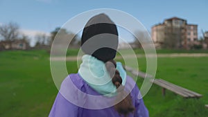 A young woman in a hat is walking intensely in the park. Side view, close-up. Follow shot. Sports Lifestyle Concept