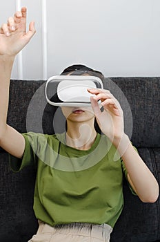 Young woman have fun in virtual reality headset or 3d glasses playing video game, gaming and technology concept.Vertical