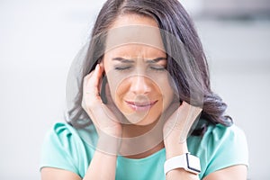 Young woman have headache migraine stress or tinnitus - noise whistling in her ears