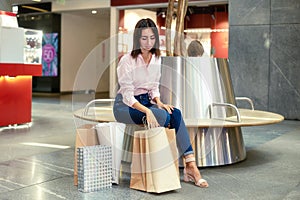 Young woman have a rest after shopping in the mall with shopping bags or packages. Fashion, clothing, sale, discount, black friday