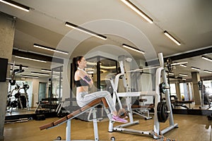 Young woman have a training at sit up bench in the gym