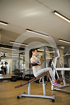 Young woman have a training at sit up bench in the gym