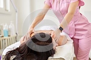 Young woman having back massage in beauty salon, relaxing while lying on comfortable couh, takes care of her skin via massage,