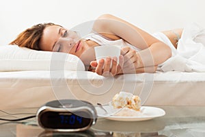 Young woman having breakfast in bed