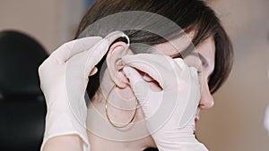 Young woman having a BTE hearing aid put in her ear