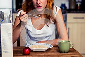 Young woman having cereal and fruit for breakfast