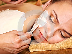 Young woman having clay body mask.