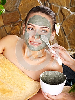 Young woman having clay body mask.