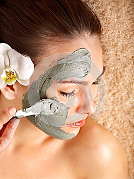 Young woman having clay body mask.