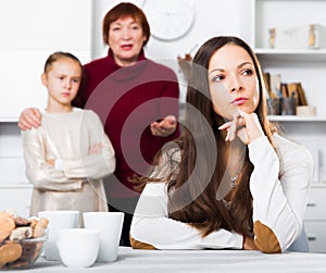Young woman having conflict with little daughter and mother