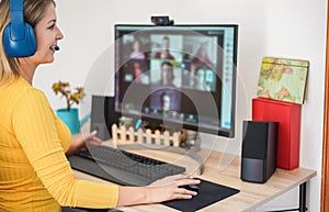 Young woman having a discussion meeting in video call with her team - Girl making webinar lesson using headphones with microphone