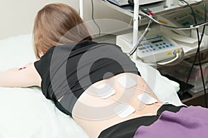 Young woman having electrotherapy treatment in clinic photo